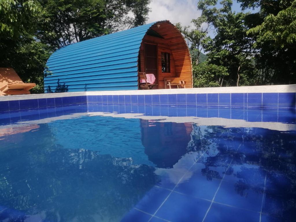 um pequeno edifício azul ao lado de uma piscina em tayrona breeze em Santa Marta