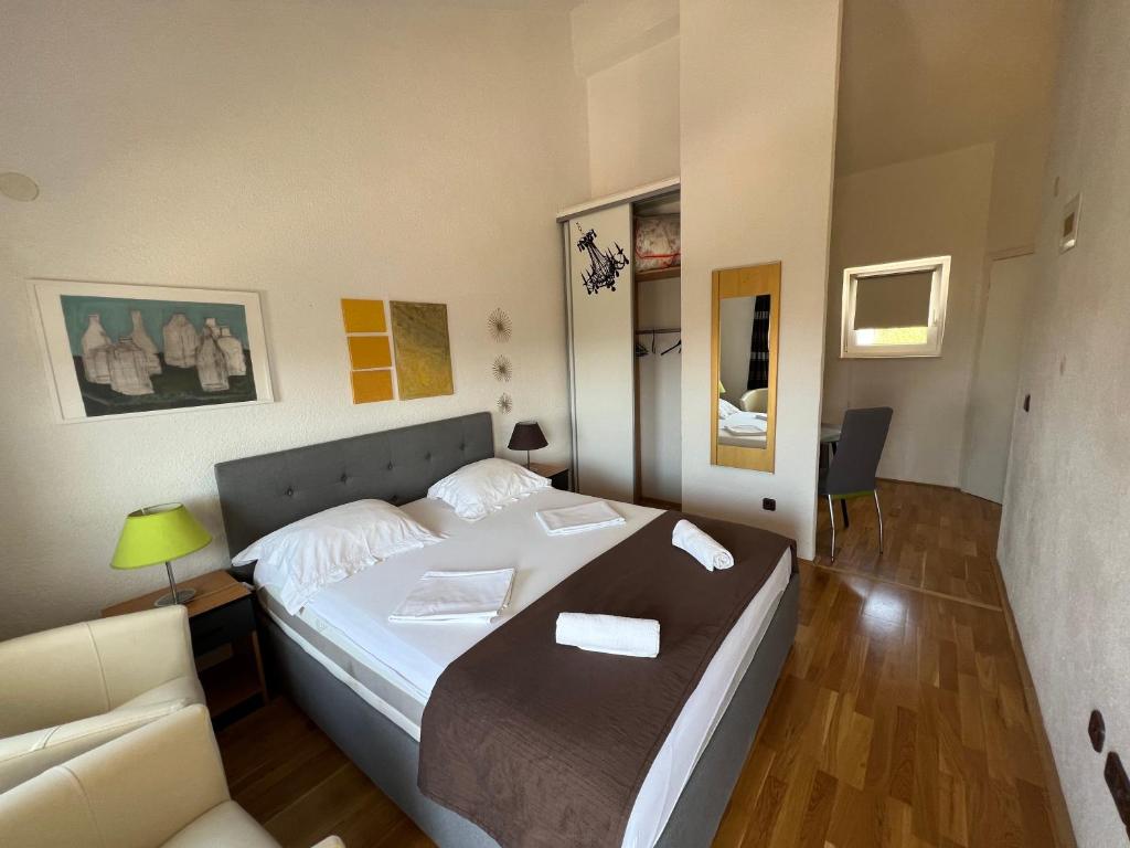1 dormitorio pequeño con 1 cama y 1 sofá en Apartmani Levarda, en Trogir