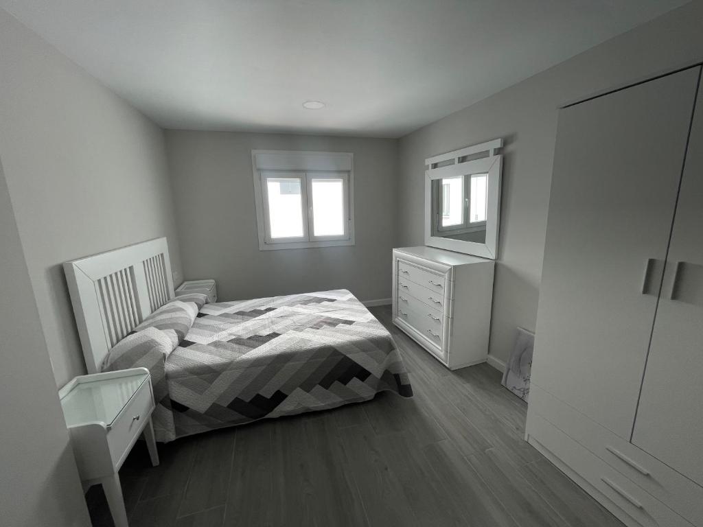 een slaapkamer met een bed, een dressoir en een spiegel bij Nuevo Azorin I in Conil de la Frontera