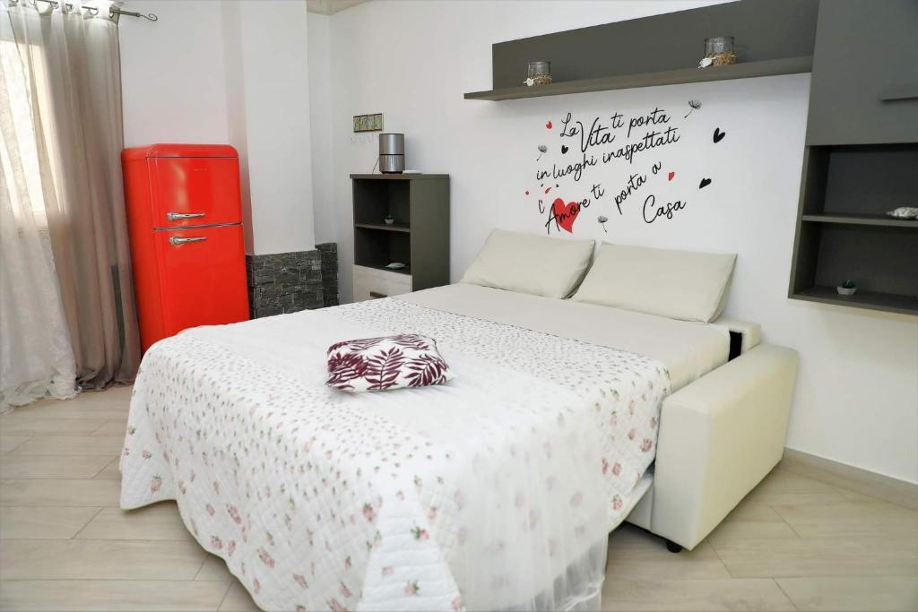 Schlafzimmer mit einem Bett und einem roten Kühlschrank in der Unterkunft Delicious Home Fondi in Fondi