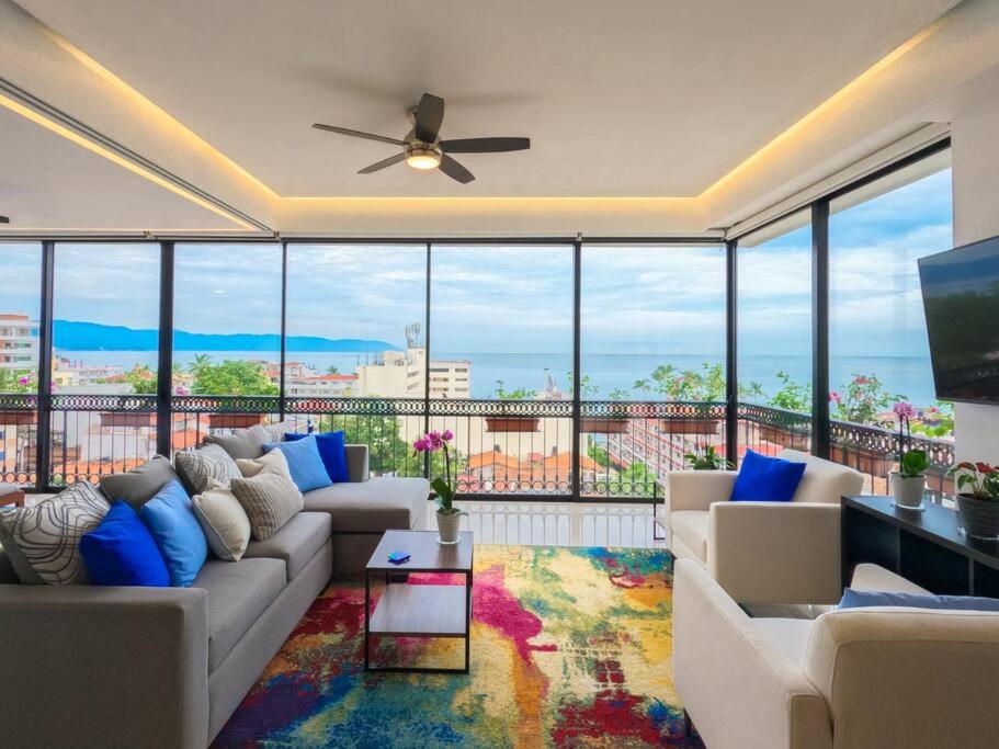 sala de estar con sofá y ventilador de techo en Luxury Oceanview Modern Condo, en Puerto Vallarta
