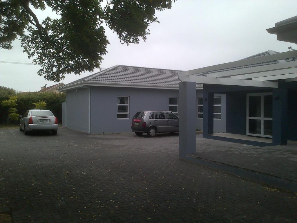 a house with two cars parked in front of it at Garden Gate Guest House in Port Elizabeth