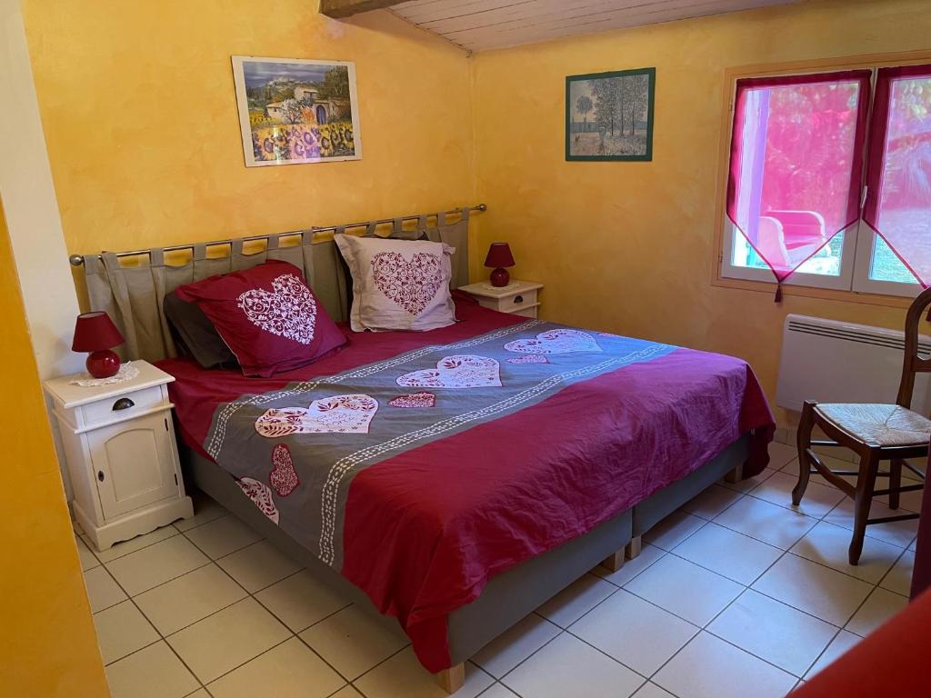 a bedroom with a bed and two tables and a window at Gîte en Drôme provençale in Les Granges-Gontardes