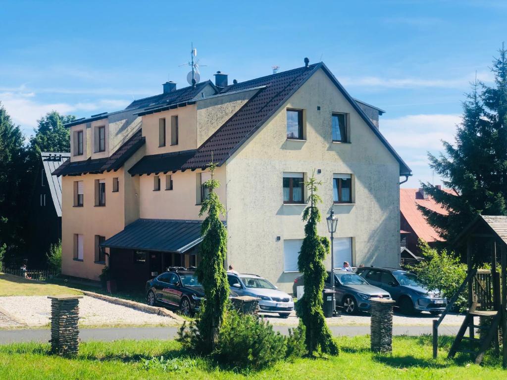 a large house with cars parked in front of it at Apartmán U Tří smrků in Boží Dar