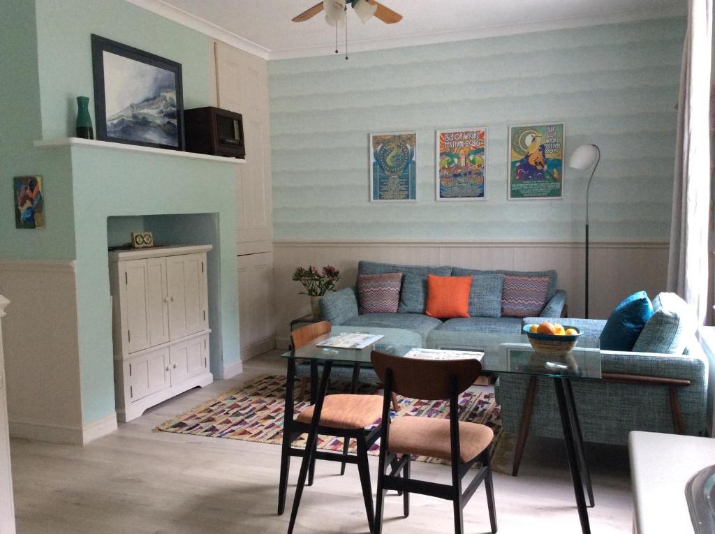 ein Wohnzimmer mit einem Sofa und einem Tisch in der Unterkunft Gulls Wing Apartment in Ventnor