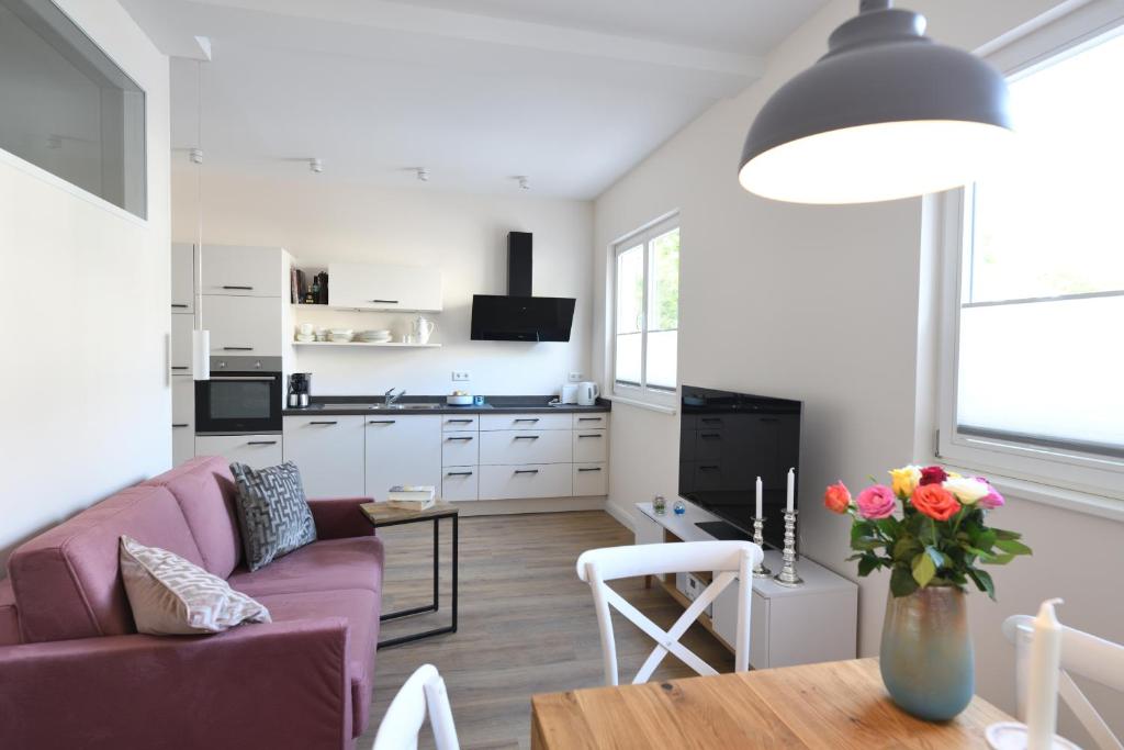 a living room with a purple couch and a table at Ferienwohnung Heppenheim - Wohnung "Starkenburg" für Familien und Paare Das schiefe Haus in Heppenheim an der Bergstrasse