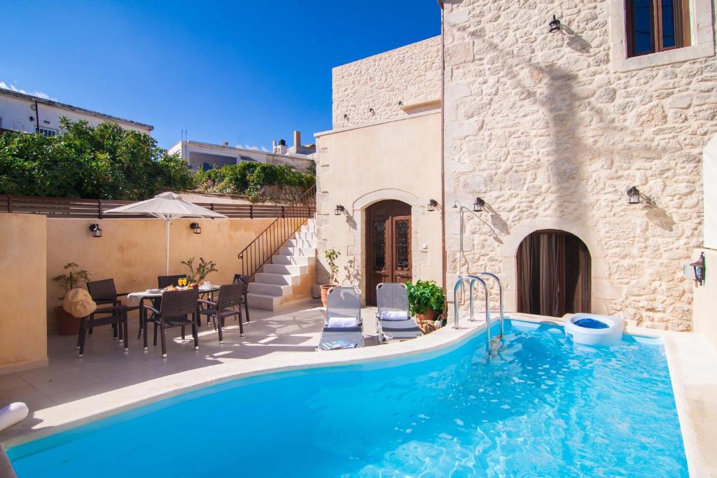 een villa met een zwembad en een patio bij Villa Zefi in Elefterna