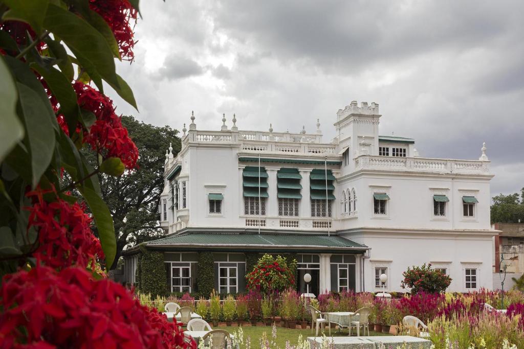 a white building with flowers in front of it at The Green Hotel in Mysore