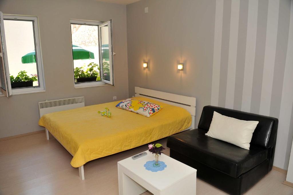 a small bedroom with a bed and a chair at Chanovi apartments in Ohrid