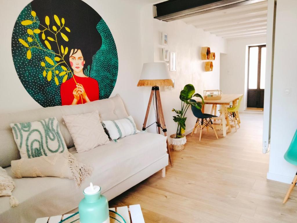 a living room with a couch and a painting on the wall at A l'Ombre de la Dame in Cucuron