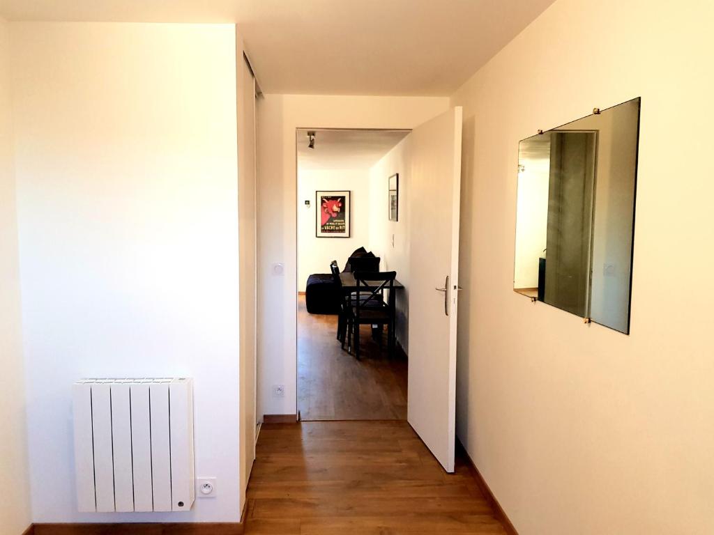 a hallway with a room with a table and a mirror at Appartement dans le bourg du Guildo - Saint-Cast in Saint-Cast-le-Guildo