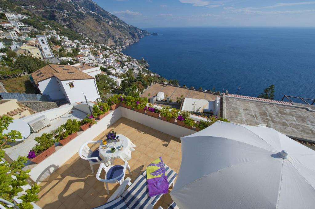 een balkon met een parasol en uitzicht op de oceaan bij Gabbiano in Praiano
