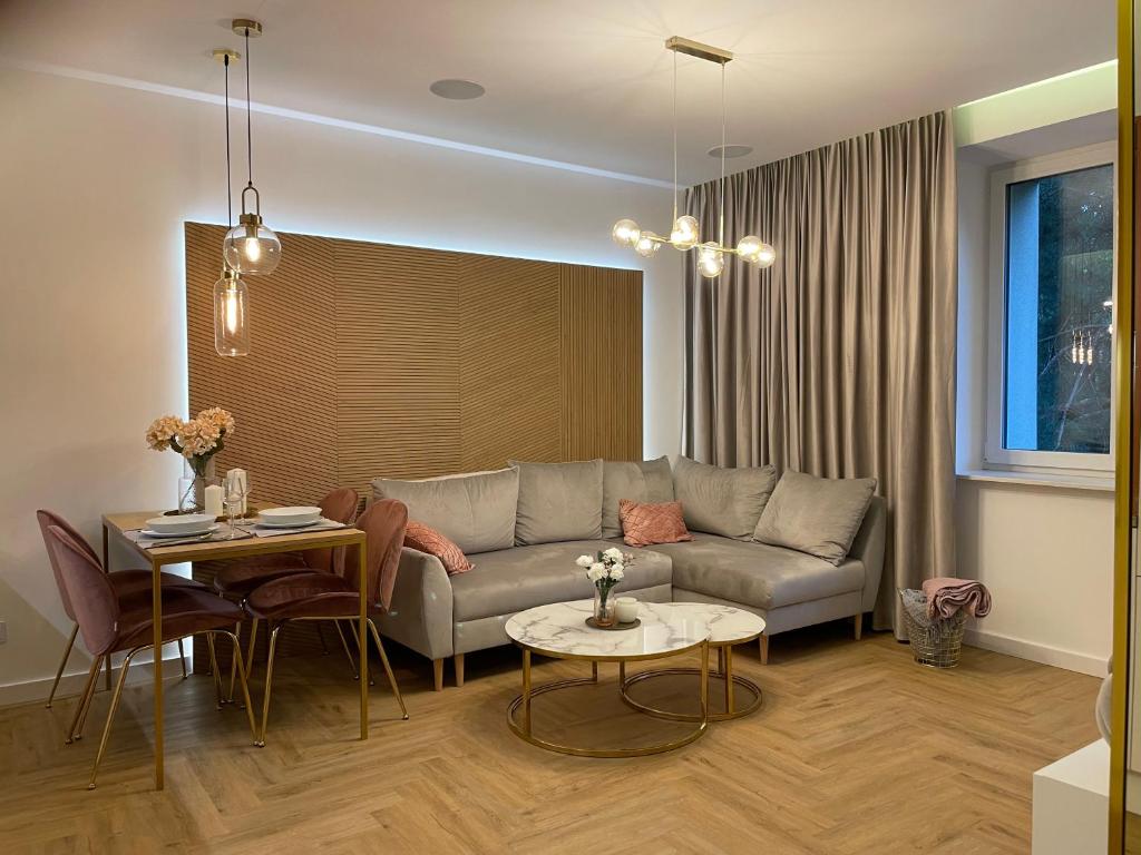 a living room with a couch and a table at CRYSTAL CAVE Apartment in Wieliczka