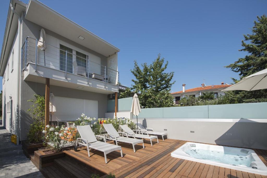 patio trasero con terraza con sillas y bañera de hidromasaje en Villa Danex Premium, en Umag