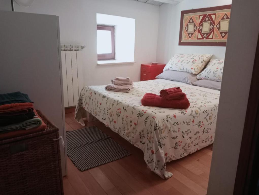 Un dormitorio con una cama con toallas rojas. en La casetta del Pastore en Sulmona