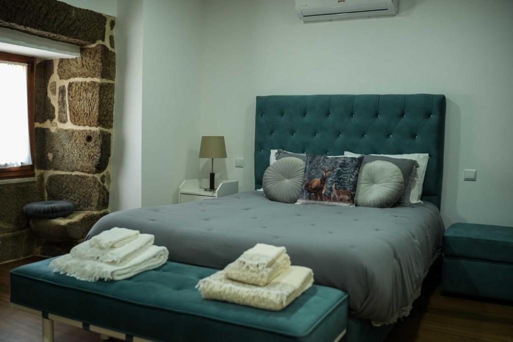 a bedroom with a blue bed with towels on a bench at Casa de Campo Gracinda in Tourém