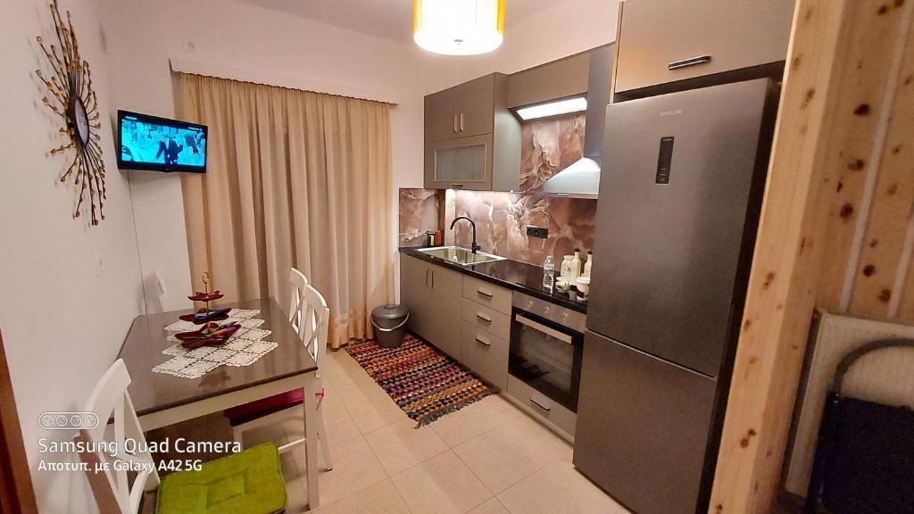 a kitchen with a stainless steel refrigerator and a table at My Zen Apartment (Κεντρικό, ήσυχο, πολλές παροχές) in Preveza