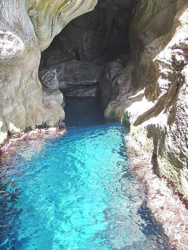 a pool of blue water in a rocky cave at Il Gabbiano Blu - Monolocale Giallo in Marettimo