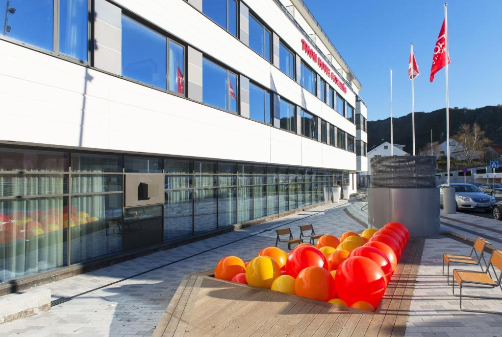 uma fila de bancos coloridos em frente a um edifício em Thon Hotel Fosnavåg em Fosnavåg