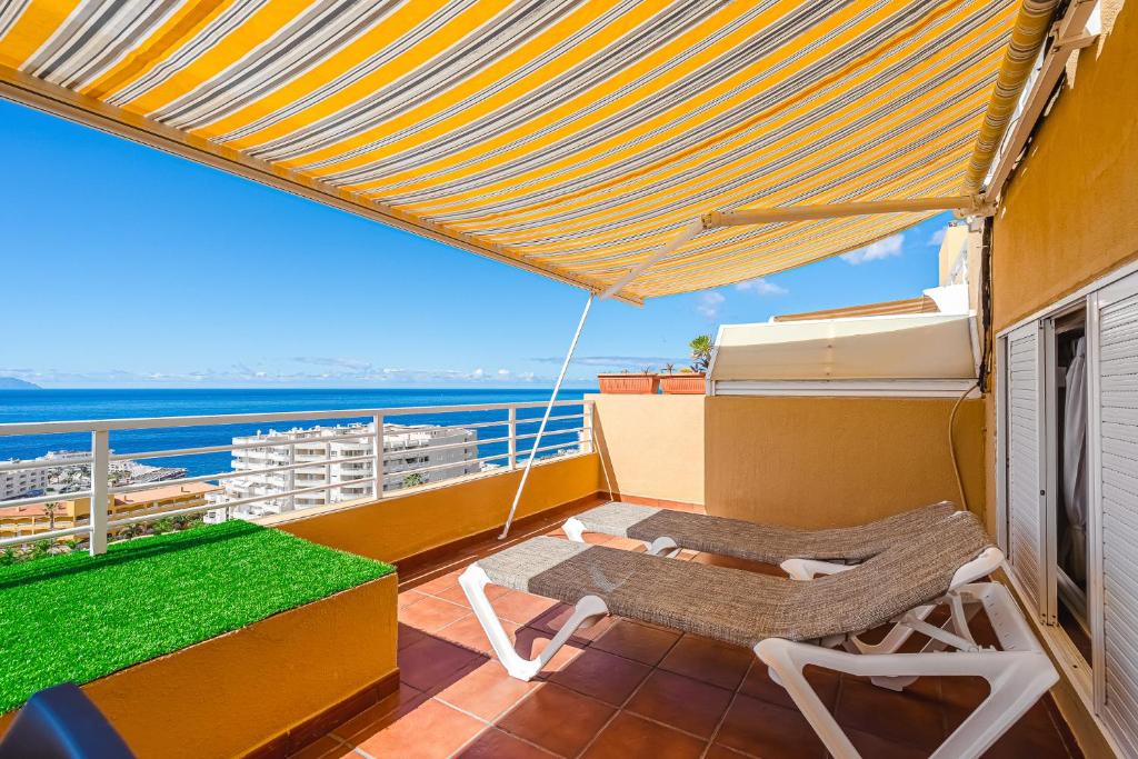 プエルト・デ・サンティアゴにあるPanomaric Sea View - Sol Apartmentのバルコニー(屋上のテーブルと椅子付)