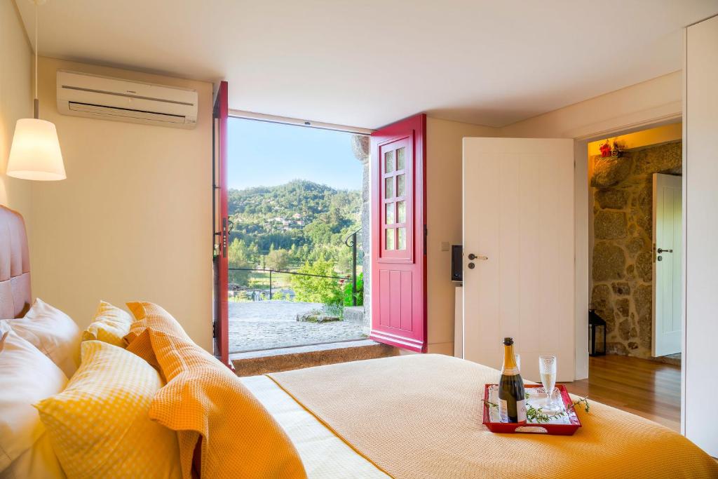 1 dormitorio con 1 cama y puerta con ventana en Quinta do Olival, en Arcos de Valdevez