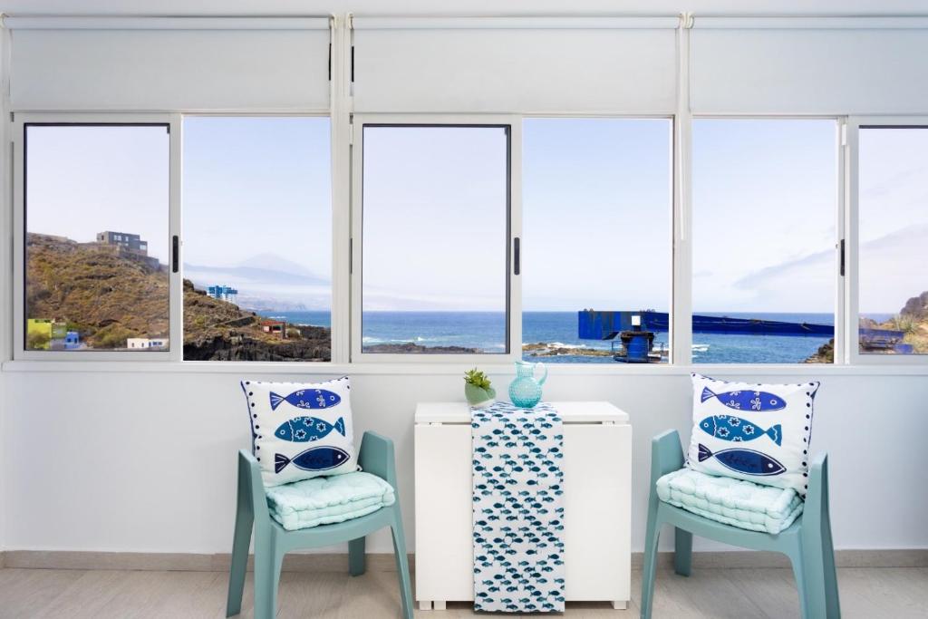 Habitación con 2 sillas, mesa y ventanas en La Fula Beach Rooms, en El Pris