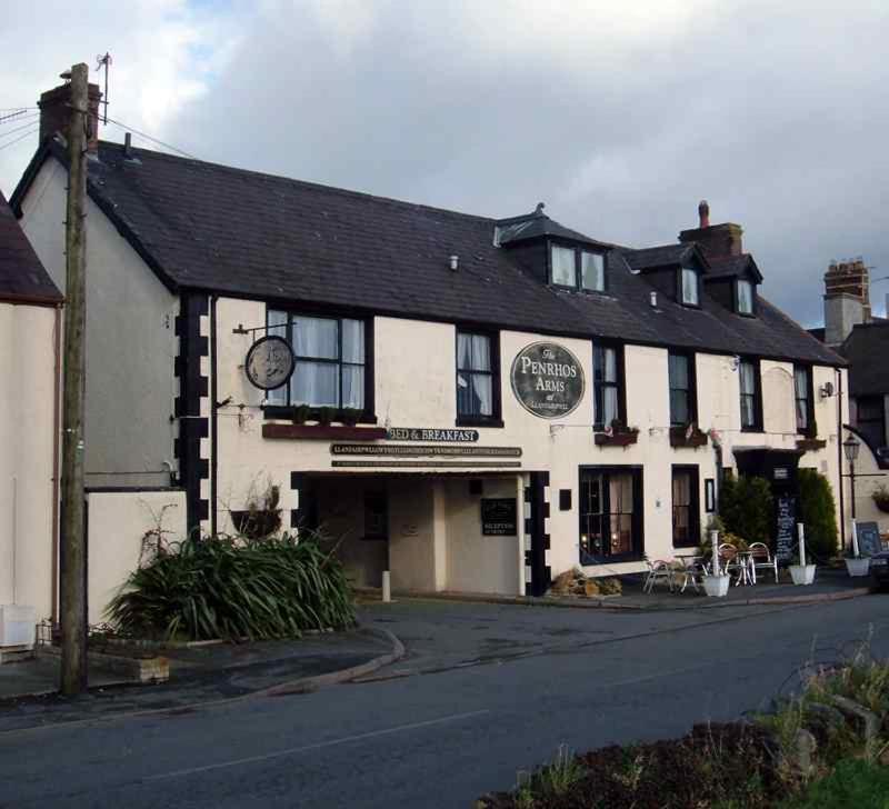 a white building with a clock on the front of it at The Penrhos Arms Hotel in Llanfairpwllgwyngyll