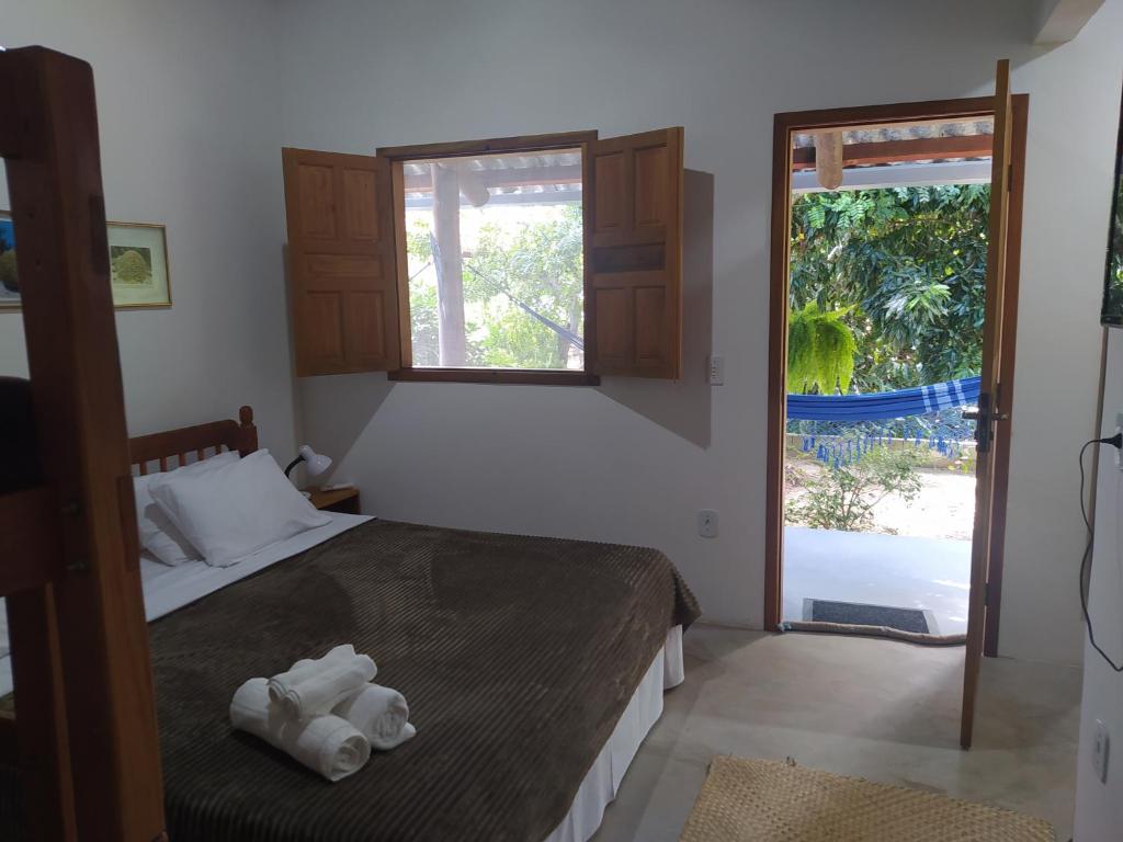 a bedroom with a bed with two towels on it at pousada corais de abrolhos in Caravelas