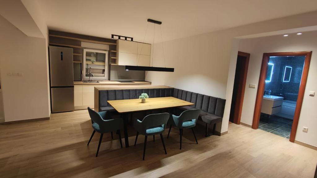 cocina y comedor con mesa de madera y sillas en Parenzo Premium Apartment, en Poreč