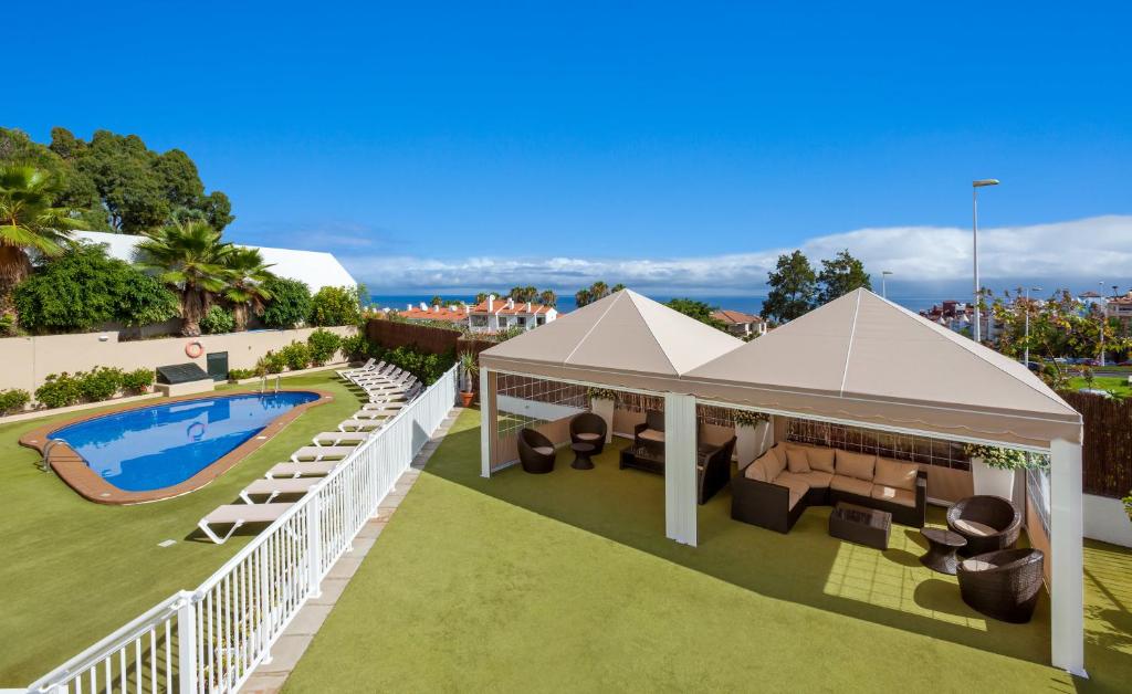 ein Bild einer Villa mit einem Pool und einem Pavillon in der Unterkunft Apartamentos Los Dragos del Norte in Puerto de la Cruz