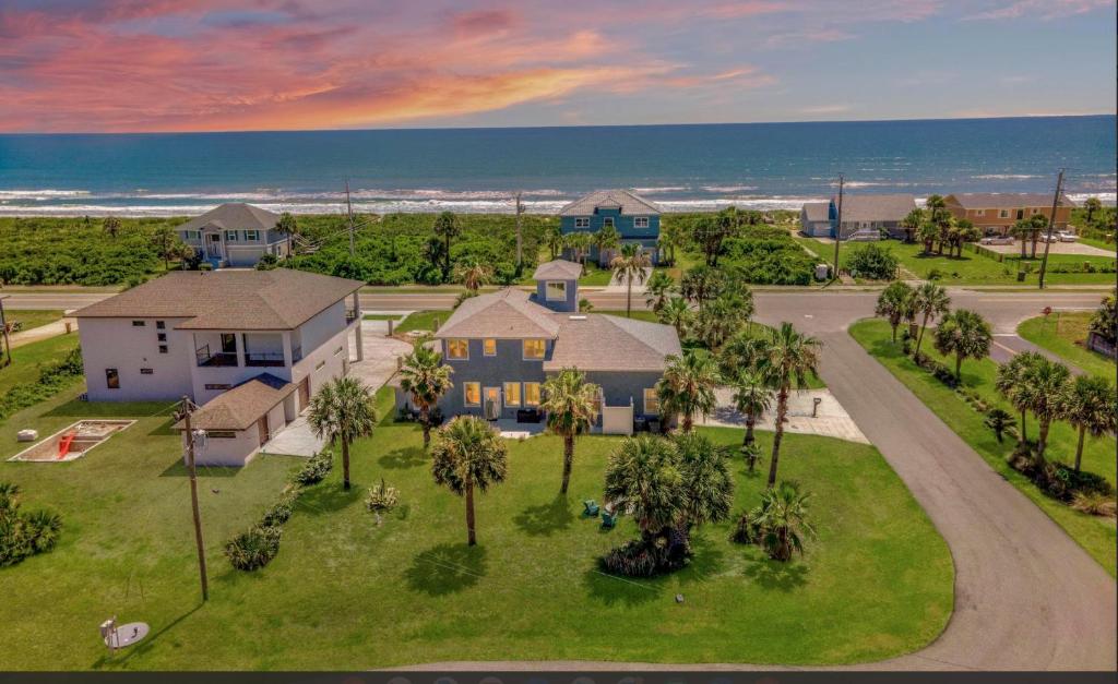 una vista aérea de una casa con palmeras y el océano en Luxury Ocean Blue beach house- 3 bed room Dog friendly en Palm Coast