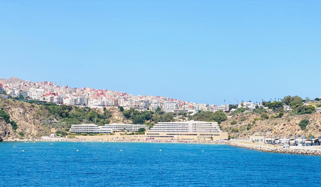 a view of a beach with buildings on a hill at Résidence Bario H in Al Hoceïma