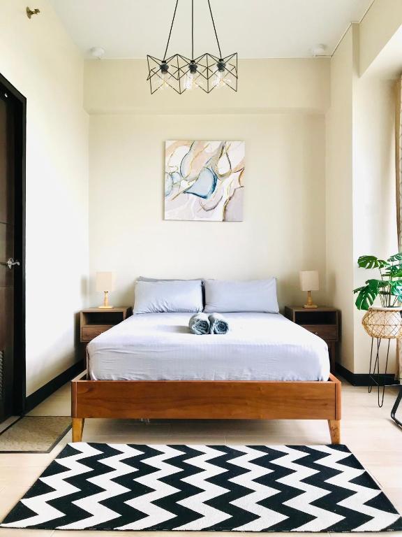 a bedroom with a bed with a black and white rug at Luxe Gold Mactan in Mactan