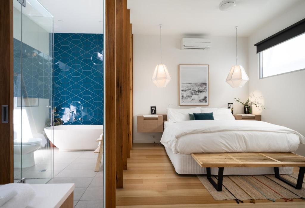 a bedroom with a bed and a bathroom with a tub at Aquabelle Apartments in Rye
