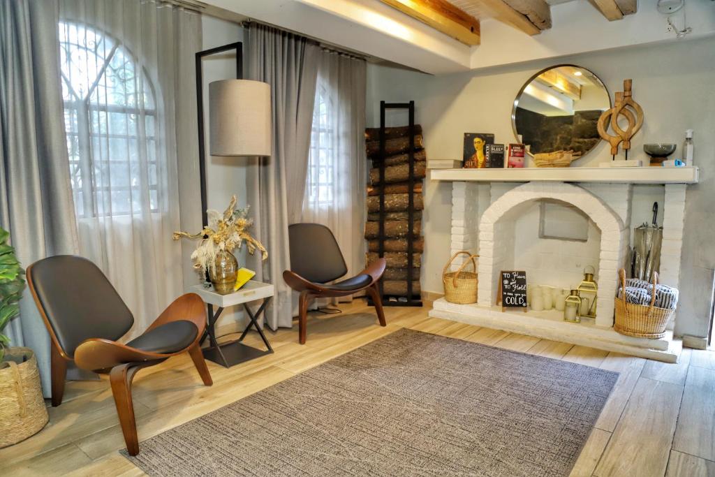 A warmly furnished sitting room with a fireplace and two lounge chairs.