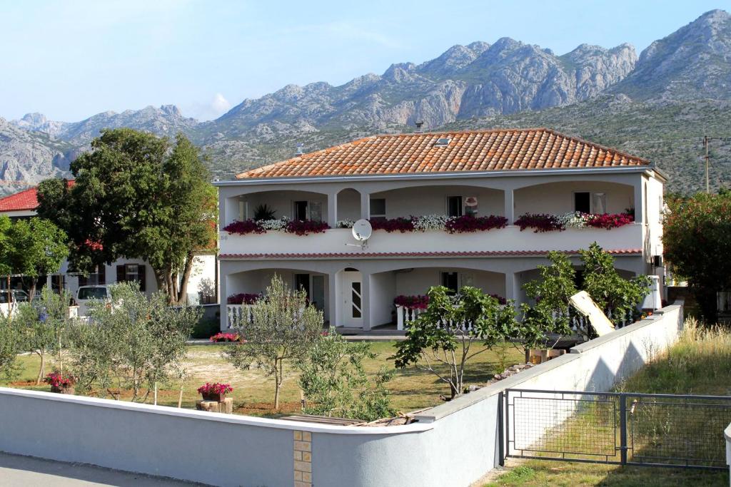 a white house with mountains in the background at Apartments with a parking space Seline, Paklenica - 6603 in Starigrad