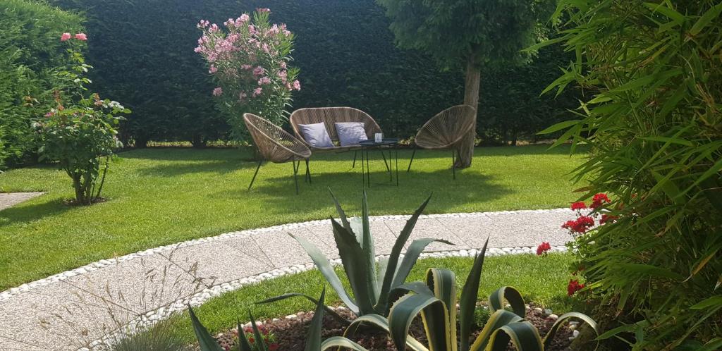 een tuin met twee stoelen en een tafel in het gras bij Casa Lola in Cavallino-Treporti