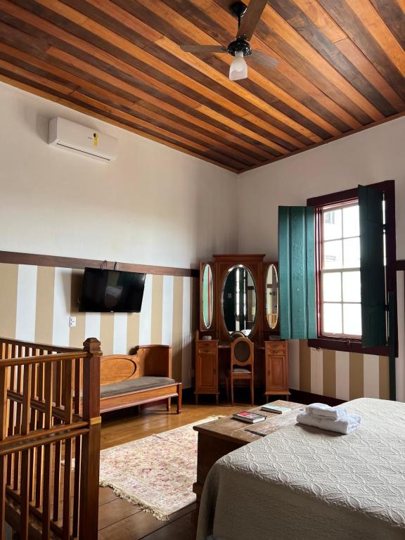 a bedroom with two beds and a wooden ceiling at Pousada Travessia - Minas Gerais in Três Pontas