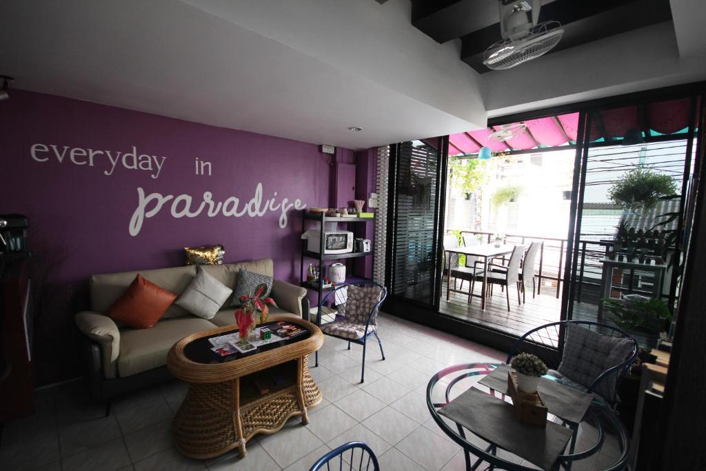 Hua Hin Paradise Guesthouse في هوا هين: غرفة معيشة مع أريكة وطاولة