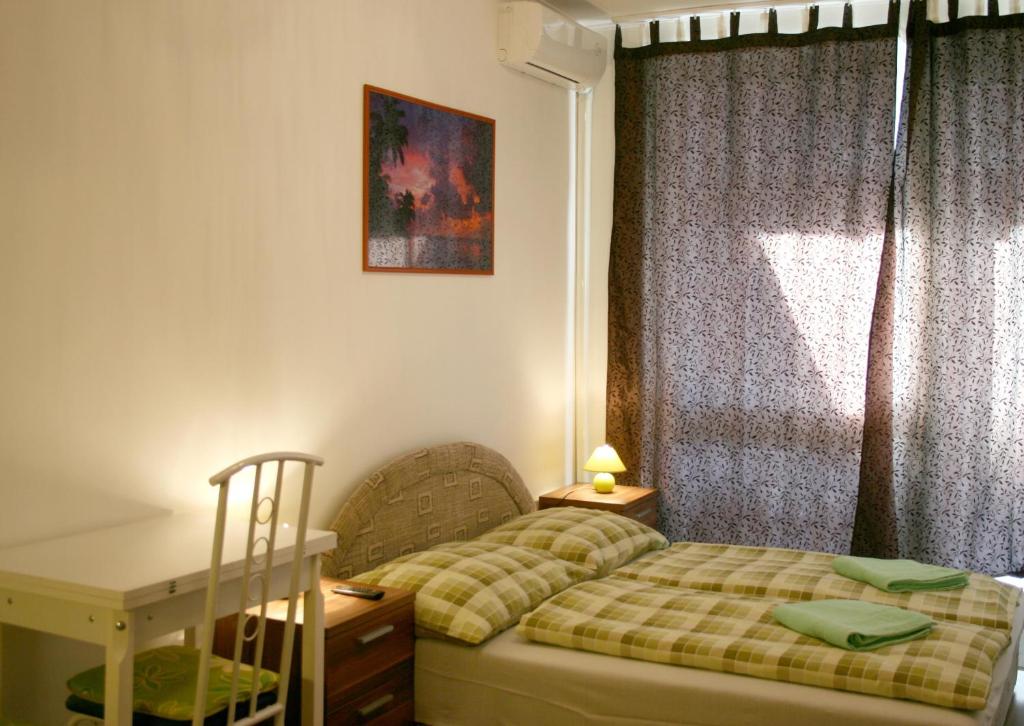 a bedroom with a bed and a desk and a window at Apartment4you Budapest in Budapest