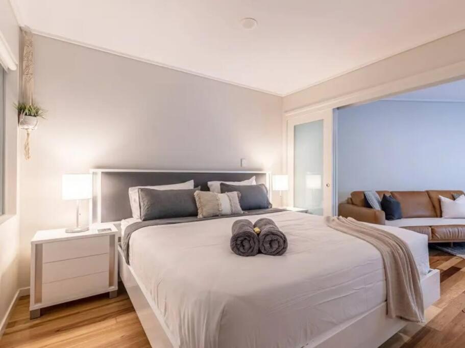 1 dormitorio con 1 cama blanca grande y 2 toallas en Tranquil Spa Suite, K-bed, Plunge Pool at Kingscliff Salt Beach Resort and Spa en Kingscliff