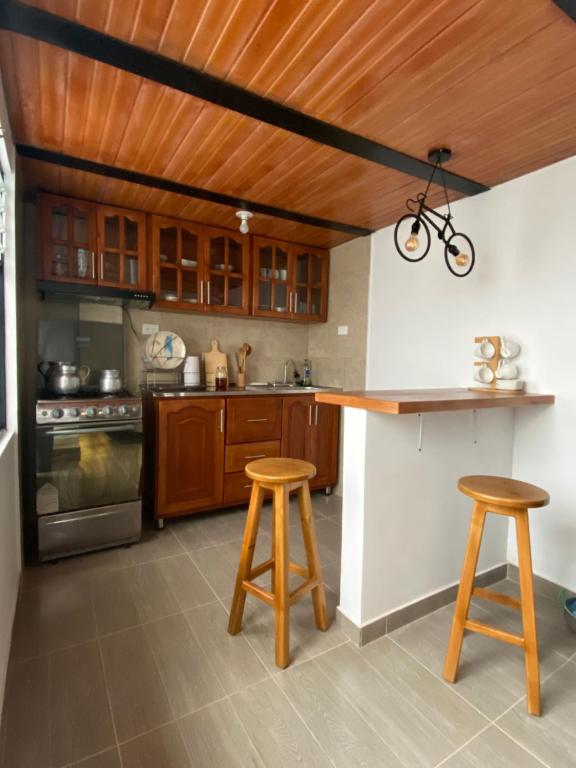 蒙圭的住宿－Hospedaje Aquitoy Sanoha，厨房配有木制橱柜和带凳子的台面