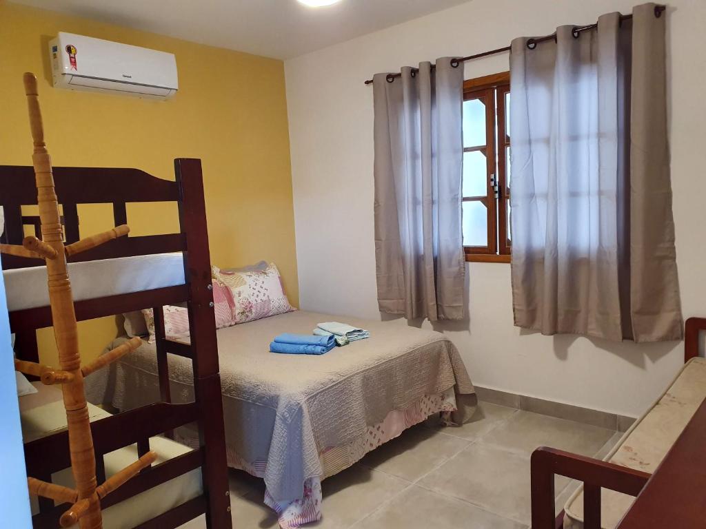 a bedroom with a bunk bed and a window at Hospedaria Cobras E Lagartos in Angra dos Reis
