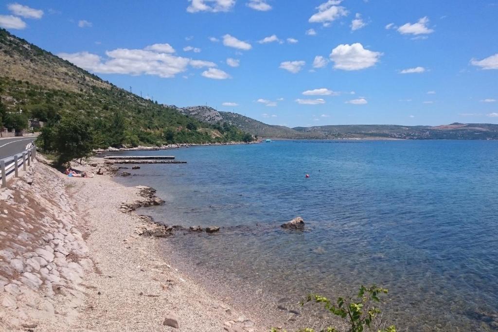 a body of water with a beach and a road at Apartment Seline 11197b in Starigrad