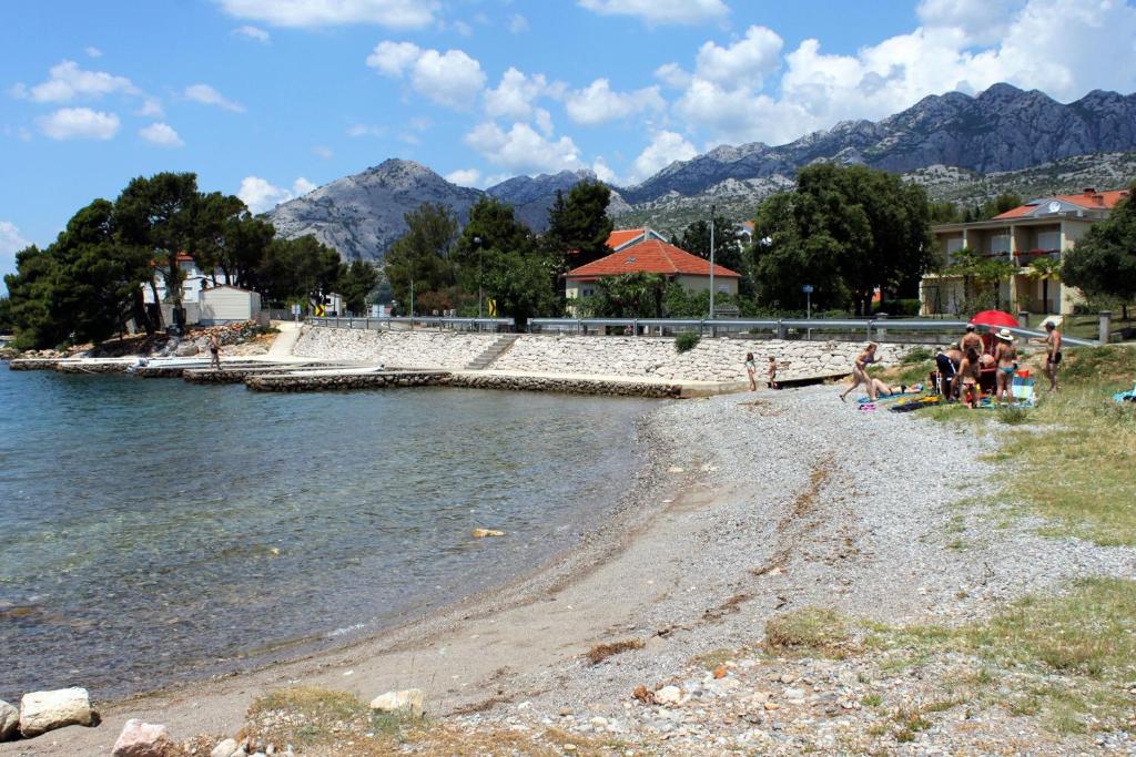 a group of people sitting on a beach near the water at Apartment Seline 11197b in Starigrad