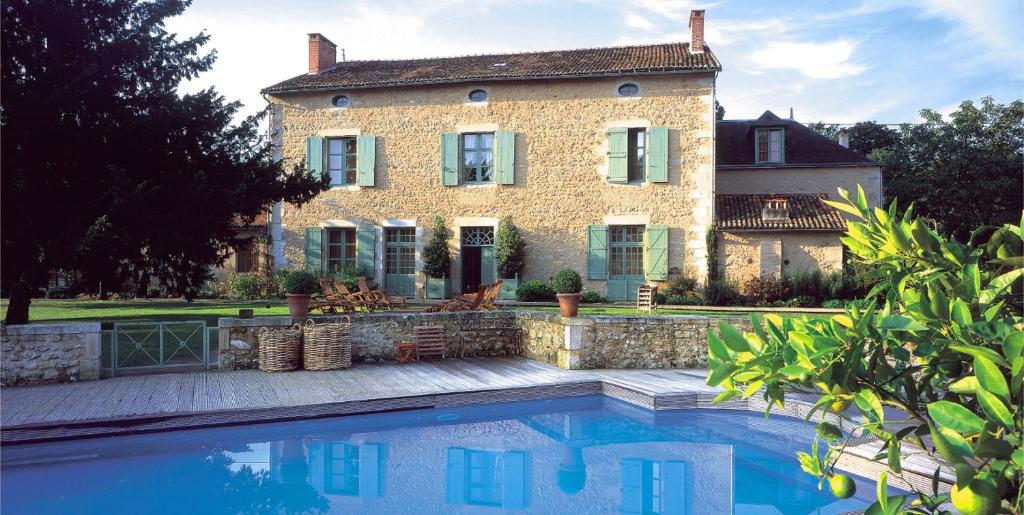 a house with a swimming pool in front of a house at Hôtel Les Orangeries in Lussac-les-Châteaux