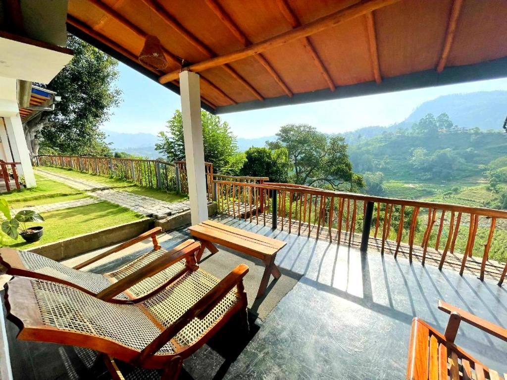 a balcony with chairs and a table and a view at Rainbow Sky Cottage in Ella
