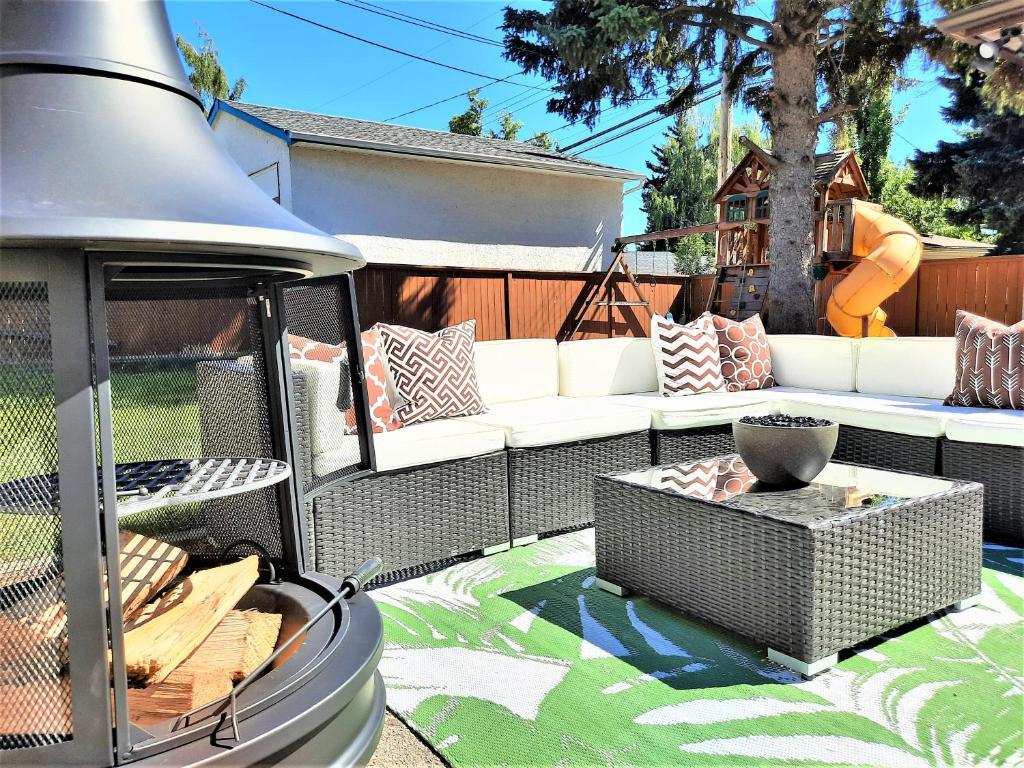 a patio with a white couch and a playground at Luxury Home By North Glenmore Park in Calgary