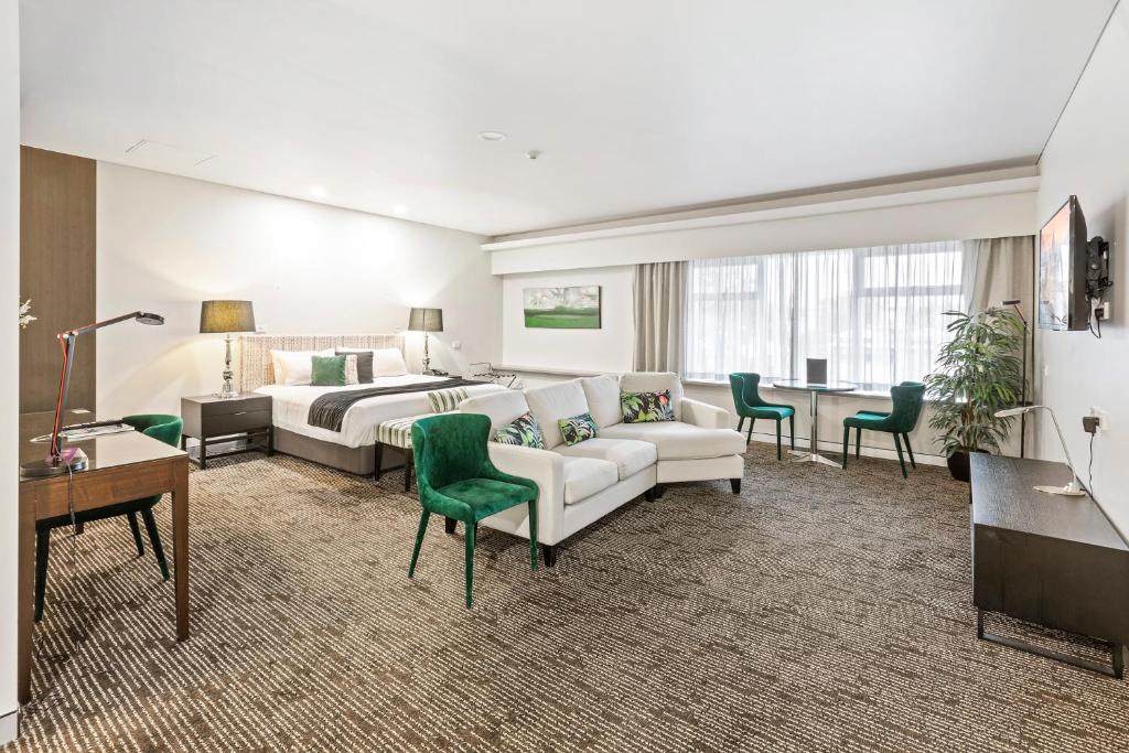una camera d'albergo con letto, divano e tavolo di The Colmslie Hotel a Brisbane
