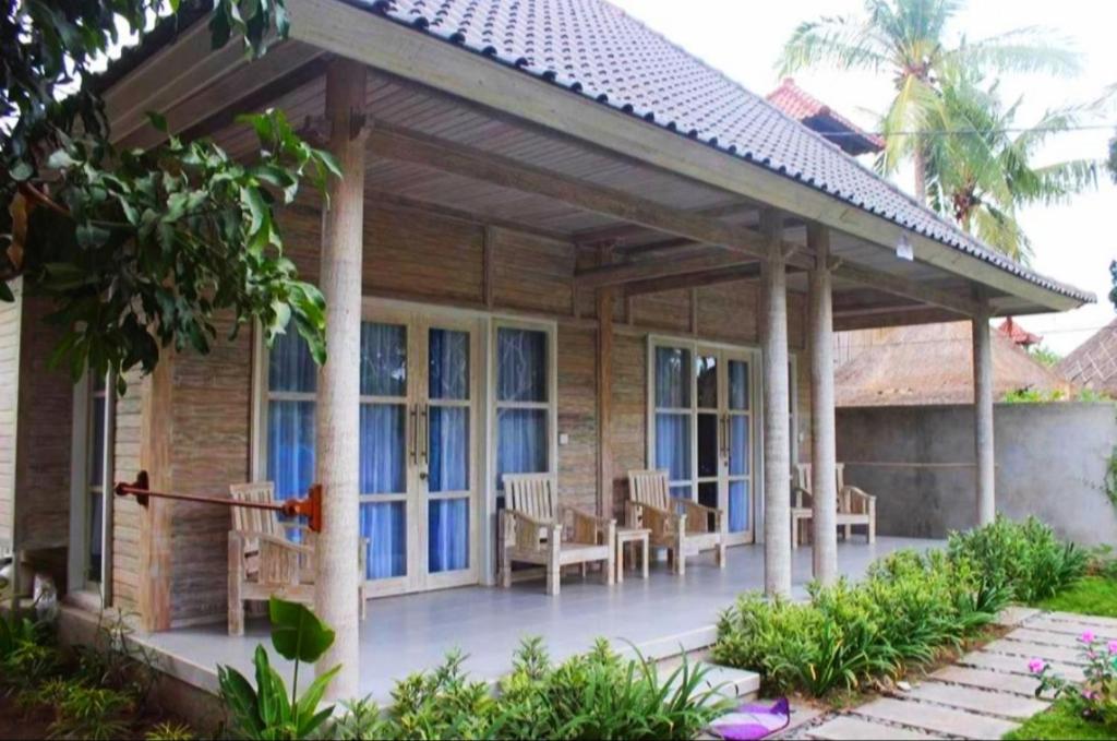 una casa con patio arredato con tavoli e sedie di Vista Huts Lembongan a Nusa Lembongan